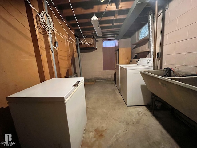 basement featuring washer and dryer and white refrigerator