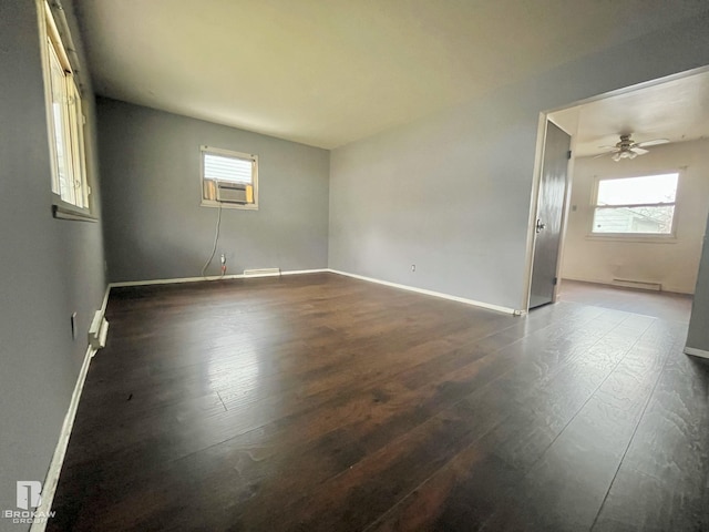 empty room featuring wood-type flooring, baseboard heating, cooling unit, and ceiling fan