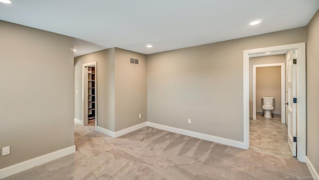 empty room featuring baseboards, recessed lighting, visible vents, and light colored carpet