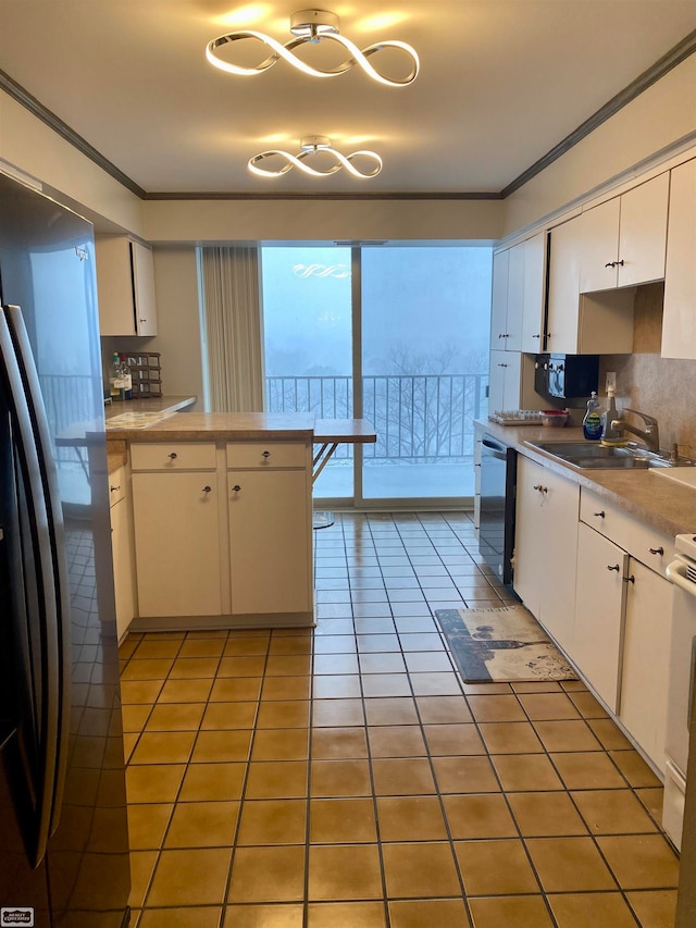 kitchen featuring appliances with stainless steel finishes, tasteful backsplash, sink, white cabinets, and light tile patterned flooring