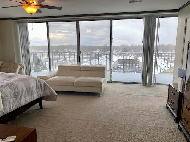 carpeted bedroom featuring multiple windows, ceiling fan, expansive windows, and access to exterior