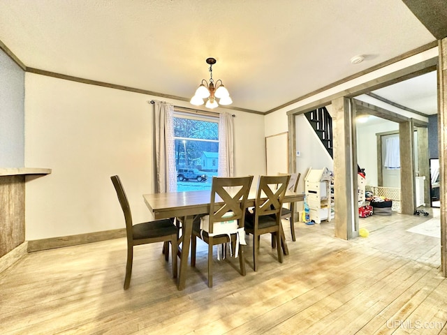 dining room featuring a chandelier, ornamental molding, and light hardwood / wood-style flooring