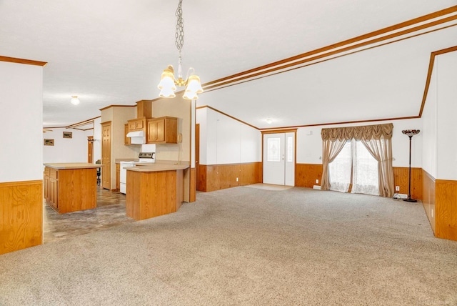 kitchen with kitchen peninsula, ornamental molding, white electric range oven, wooden walls, and a kitchen island