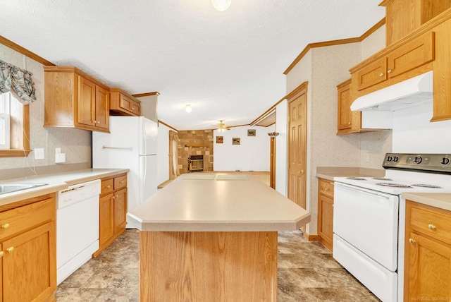 kitchen featuring ornamental molding, a textured ceiling, white appliances, ceiling fan, and a kitchen island