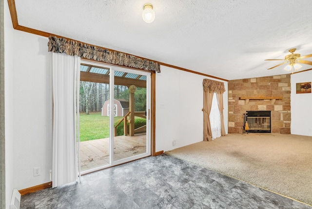 unfurnished living room featuring crown molding, carpet flooring, ceiling fan, a fireplace, and a textured ceiling