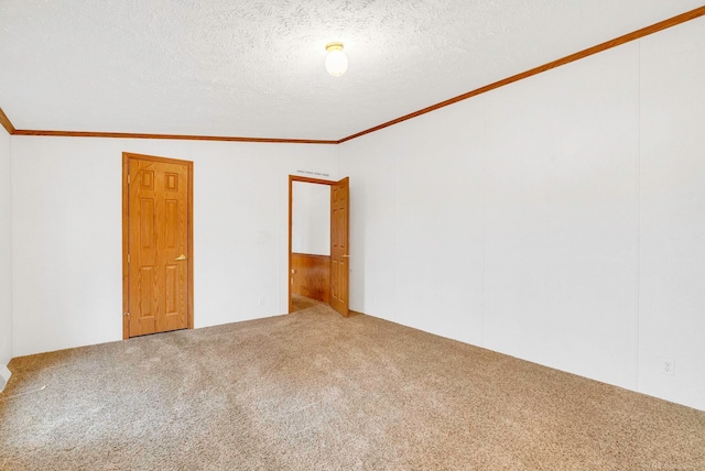 unfurnished room featuring carpet flooring, crown molding, vaulted ceiling, and a textured ceiling