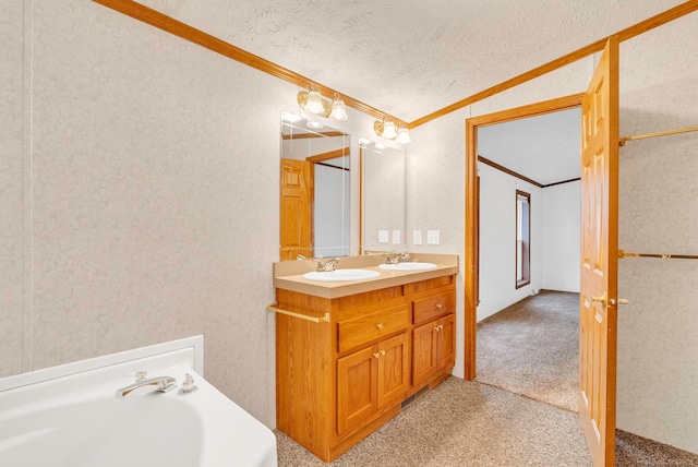 bathroom featuring a washtub, vanity, a textured ceiling, and crown molding