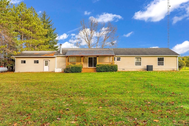 back of property with central air condition unit and a yard