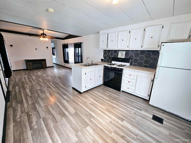 kitchen with white appliances, sink, kitchen peninsula, light wood-type flooring, and white cabinetry