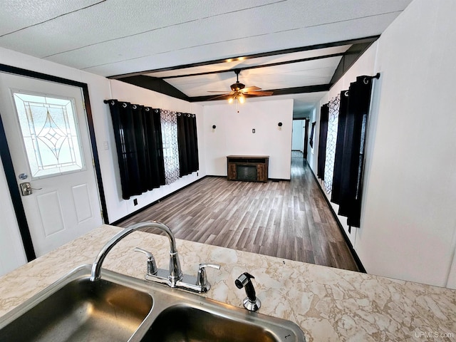 kitchen with vaulted ceiling with beams, ceiling fan, sink, and dark wood-type flooring