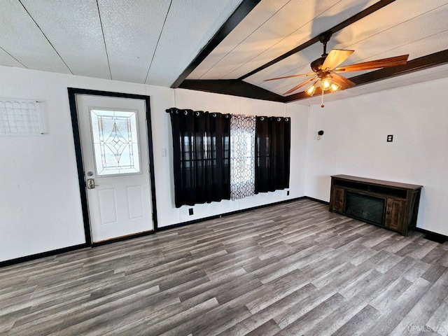 foyer entrance with vaulted ceiling with beams, ceiling fan, a textured ceiling, and hardwood / wood-style flooring