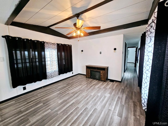 unfurnished living room with lofted ceiling with beams, hardwood / wood-style flooring, and ceiling fan