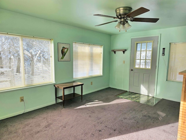 doorway to outside featuring ceiling fan and dark carpet