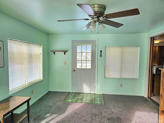 doorway featuring carpet floors and ceiling fan