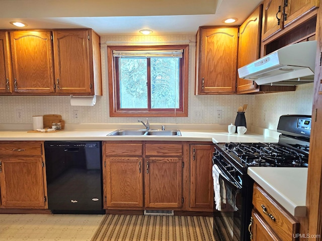 kitchen with black appliances, sink, and range hood