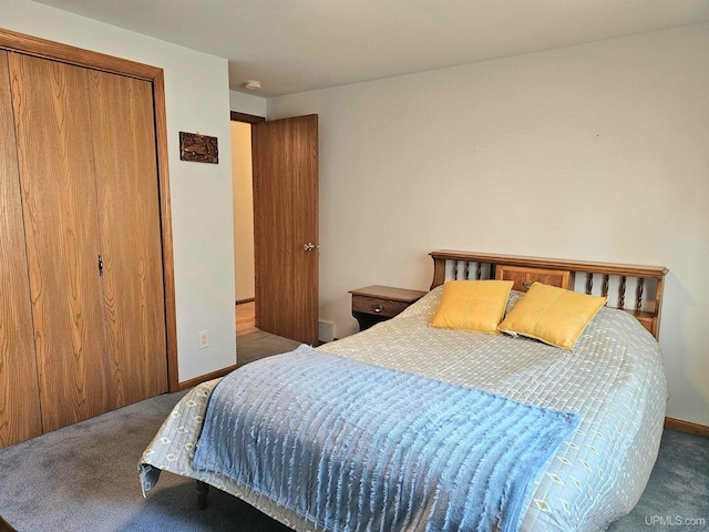 bedroom with dark colored carpet and a closet