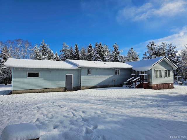 view of snow covered back of property