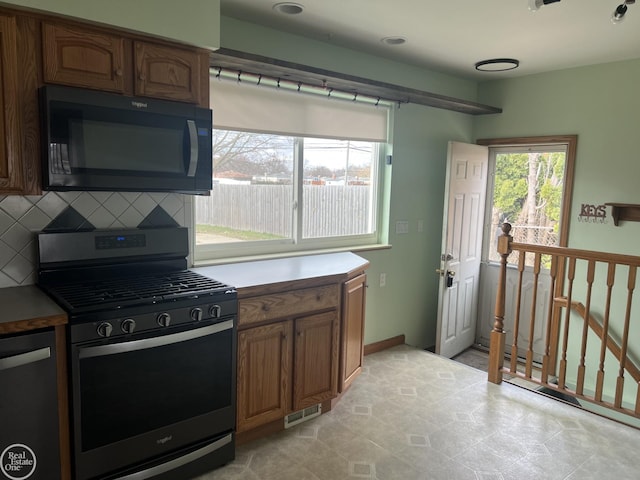 kitchen with light tile patterned floors, stainless steel appliances, and tasteful backsplash