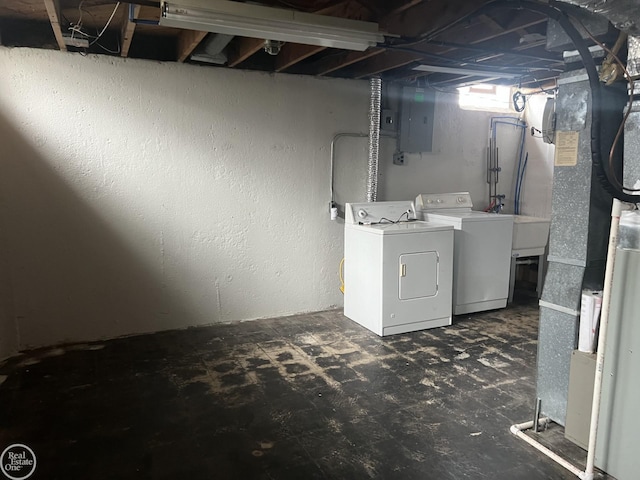 basement featuring separate washer and dryer, electric panel, and heating unit