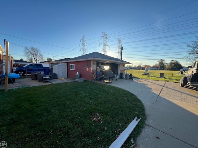 view of home's exterior with a lawn, a patio, and a storage shed