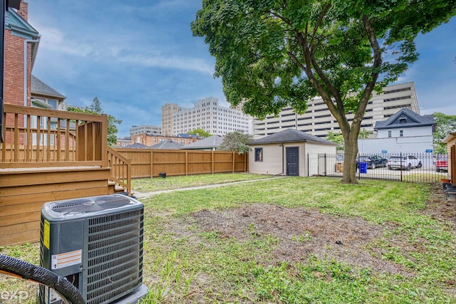 view of yard featuring a deck, central AC unit, and an outdoor structure