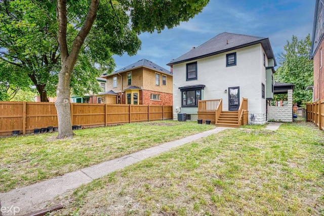 back of property with a lawn and central AC unit