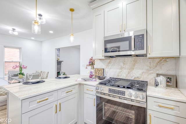 kitchen with light stone countertops, kitchen peninsula, stainless steel appliances, decorative light fixtures, and white cabinetry