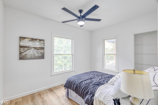 bedroom featuring multiple windows, ceiling fan, and light wood-type flooring