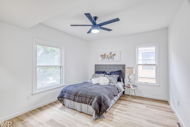 bedroom with light hardwood / wood-style floors, multiple windows, and ceiling fan