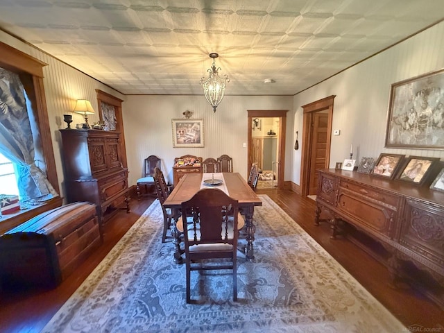 dining area featuring dark wood-type flooring and an inviting chandelier