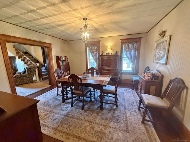 dining area with hardwood / wood-style flooring and an inviting chandelier