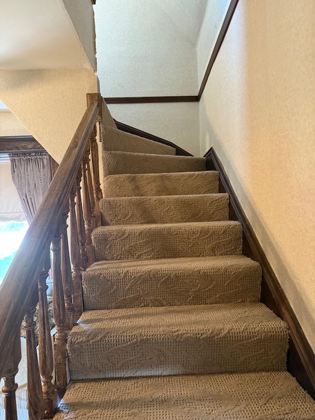 staircase featuring lofted ceiling