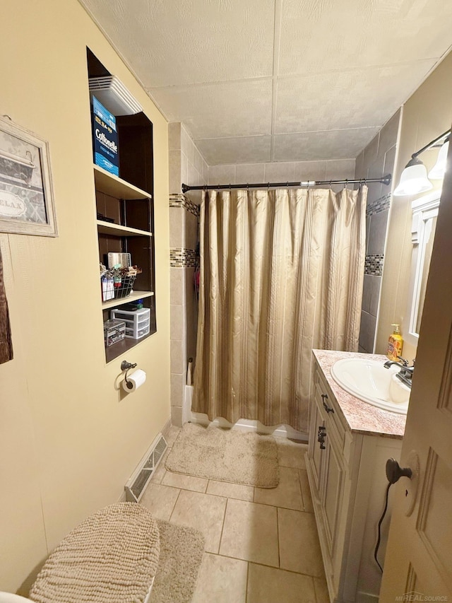 bathroom featuring tile patterned flooring, vanity, shower / bathtub combination with curtain, and built in shelves