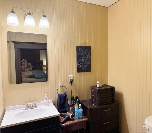 bathroom featuring wooden walls and vanity