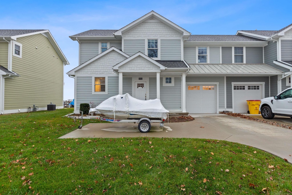 view of front of property with central AC, a front lawn, and a garage