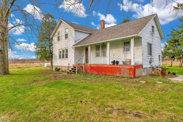 back of property with a lawn and covered porch