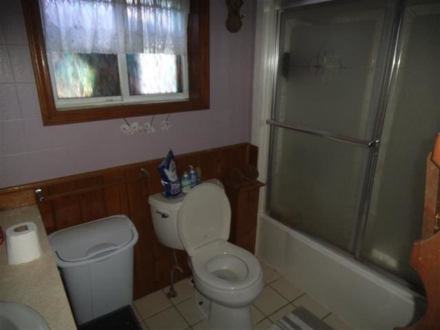 full bathroom featuring tile patterned floors, sink, bath / shower combo with glass door, and toilet