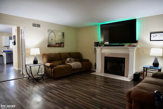 living room featuring dark hardwood / wood-style floors and a tile fireplace