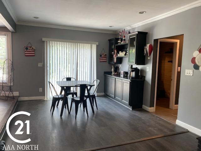 dining area featuring dark hardwood / wood-style floors and ornamental molding