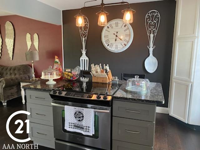 kitchen featuring electric range, dark hardwood / wood-style floors, gray cabinets, and dark stone counters