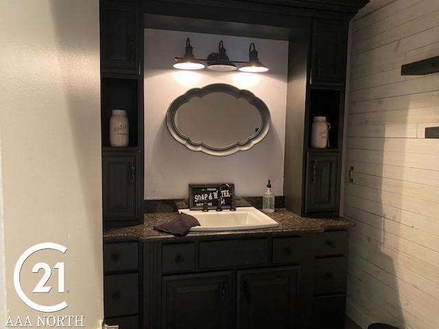 bathroom featuring wooden walls and vanity