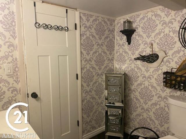 bathroom with ornamental molding and toilet