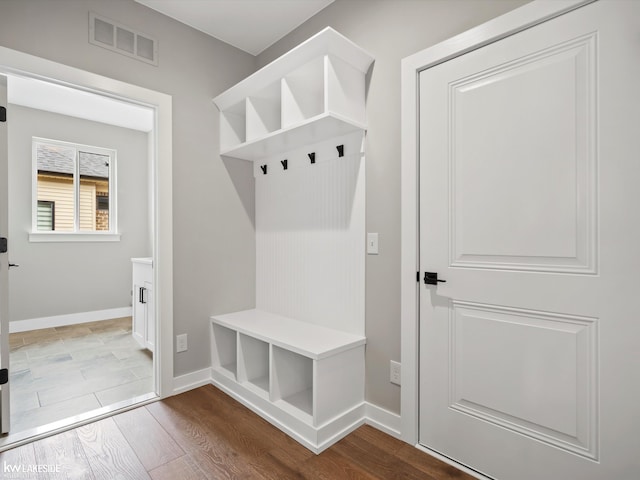 mudroom featuring wood finished floors, visible vents, and baseboards