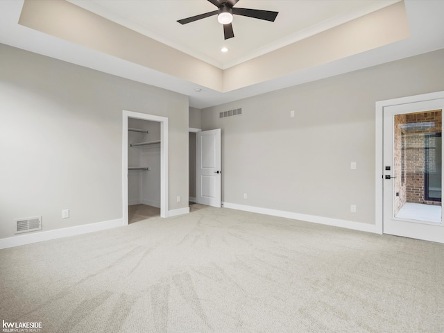 unfurnished bedroom featuring a raised ceiling, visible vents, and baseboards