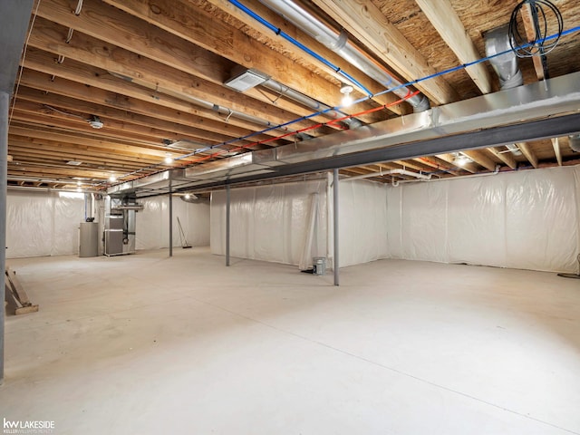 unfinished basement with gas water heater and heating unit