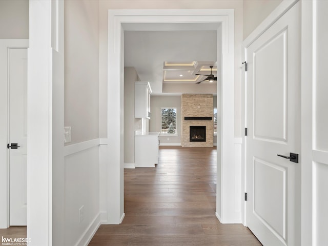 hallway featuring dark wood-type flooring, coffered ceiling, beam ceiling, and baseboards