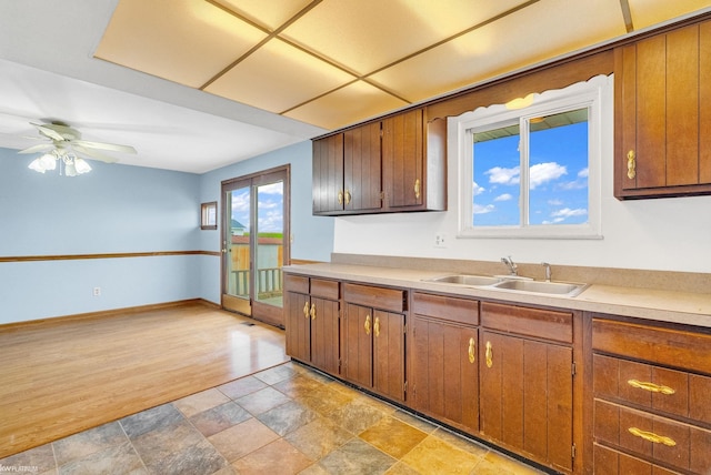 kitchen with ceiling fan, sink, and light wood-type flooring