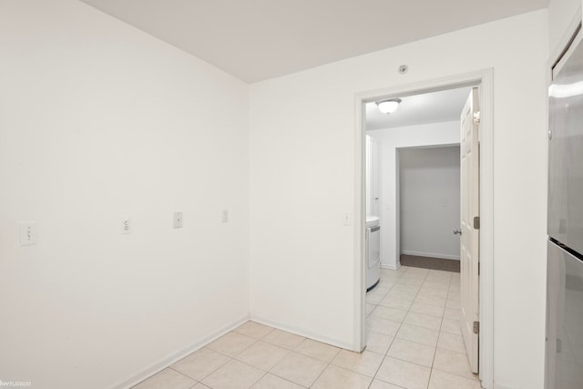 tiled spare room featuring washer / dryer