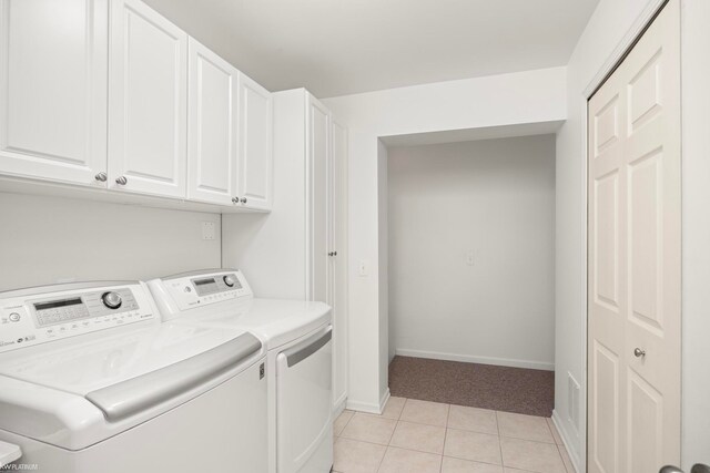 laundry area with cabinets, light tile patterned floors, and separate washer and dryer