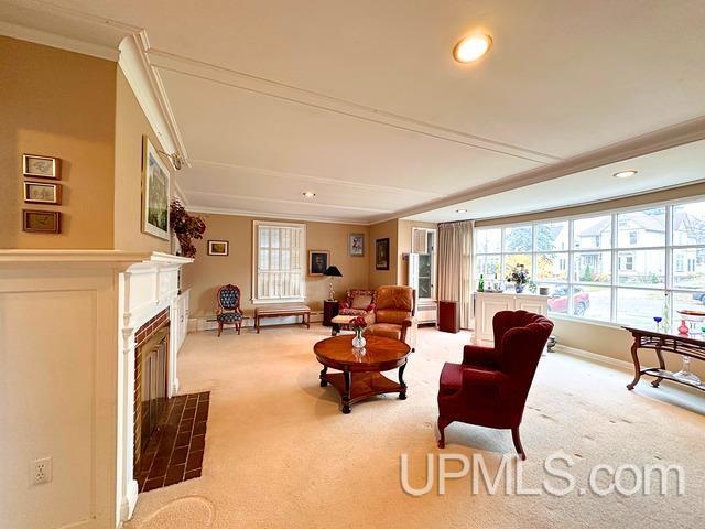 carpeted living room featuring crown molding